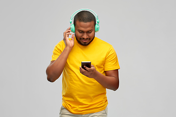 Image showing african man with headphones and smartphone