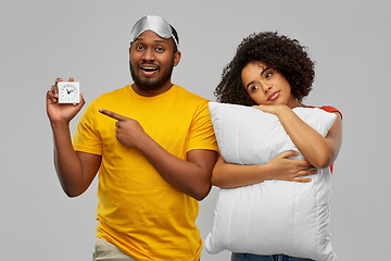 Image showing couple with alarm clock, sleeping mask and pillow