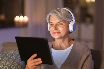 Image showing senior woman in headphones listening to music