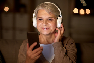 Image showing senior woman in headphones listening to music