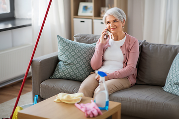 Image showing old woman calling on cellphone after cleaning home