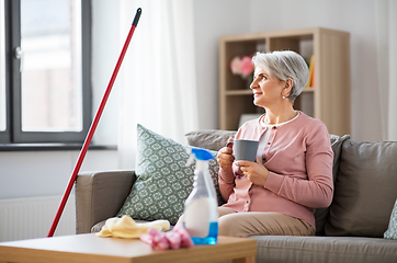 Image showing senior woman drinking coffee after home cleaning