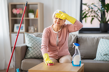 Image showing tired senior woman cleaning table at home