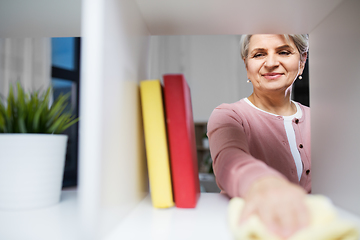 Image showing happy senior woman with cloth dusting rack at home