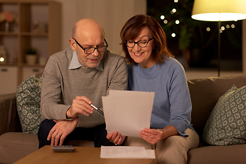 Image showing senior couple with papers and calculator at home