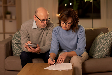 Image showing senior couple with papers and calculator at home