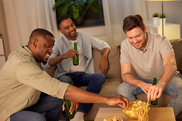 Image showing male friends drinking beer with crisps at home