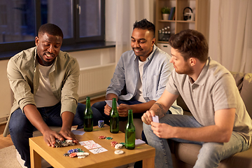 Image showing smiling male friends playing cards at home