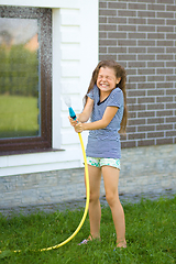 Image showing Happy girl pouring water from a hose