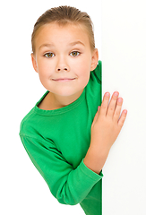 Image showing Little girl is looking from out blank board