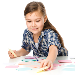 Image showing Girl is writing on color stickers using pen