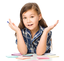 Image showing Girl is writing on color stickers using pen