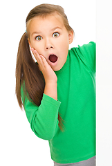 Image showing Little girl is looking out from the blank banner