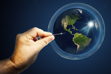 Image showing Planet earth in a soap bubble and a hand with a needle that burs