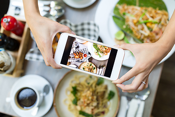 Image showing Mobile phone taking photo on food from top in restaurant