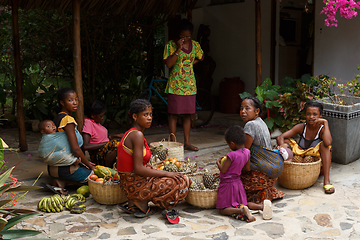 Image showing Malagasy women preparing basket of fruit for street market sale,