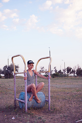 Image showing Beautiful woman in black and white striped swimsuit on the old sports ground. Film effect.