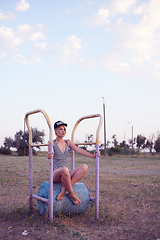 Image showing Beautiful woman in black and white striped swimsuit on the old sports ground. Film effect.