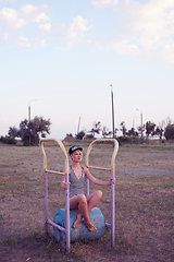 Image showing Beautiful woman in black and white striped swimsuit on the old sports ground. Film effect.