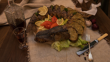 Image showing Stuffed pike with vegetables and greens.