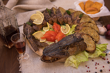 Image showing Stuffed pike with vegetables and greens.