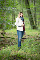 Image showing young woman standing in the green forest