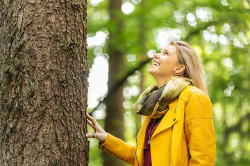 Image showing young woman standing at the tree