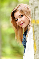 Image showing young woman standing in the green forest