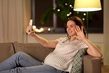 Image showing happy smiling pregnant woman taking selfie at home