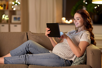 Image showing happy pregnant woman with tablet pc at home