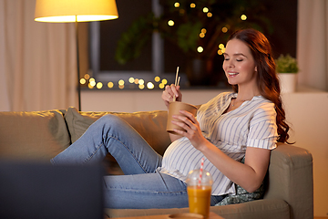 Image showing pregnant woman watching tv and eating wok at home