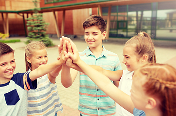 Image showing group of children making high five at school yard