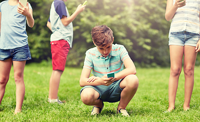 Image showing kids with smartphones playing game in summer park