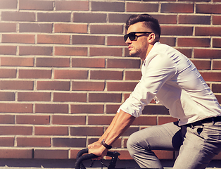 Image showing young man riding bicycle on city street