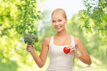 Image showing happy smiling young woman with heart and broccoli