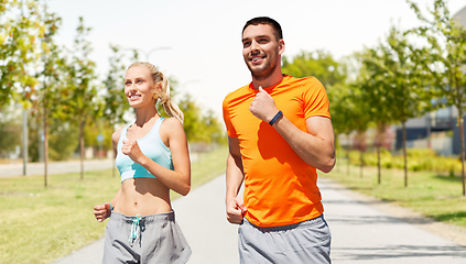 Image showing happy couple with fitness trackers running outdoor