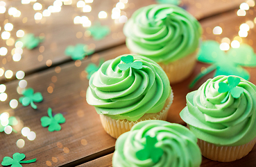 Image showing green cupcakes and shamrock on wooden table