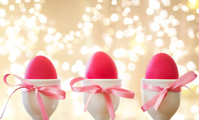 Image showing pink easter eggs in holders over festive lights