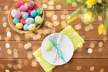 Image showing easter eggs in basket, plates, cutlery and flowers