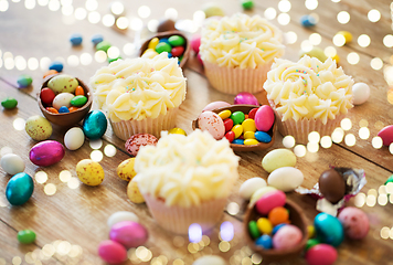 Image showing cupcakes with easter eggs and candies on table