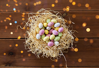 Image showing easter eggs in straw nest on wooden table