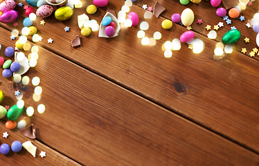 Image showing chocolate eggs and candy drops on wooden table