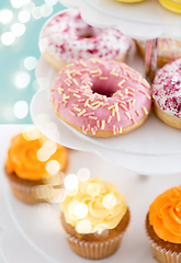 Image showing close up of glazed donuts and cupcakes on stand