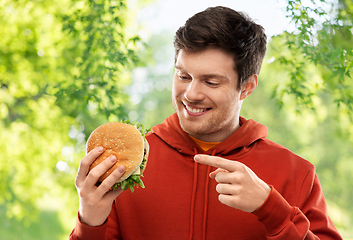 Image showing happy young man showing hamburger