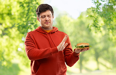 Image showing young man refusing from hamburger