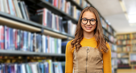 Image showing smiling teenage student girl in glasses at library