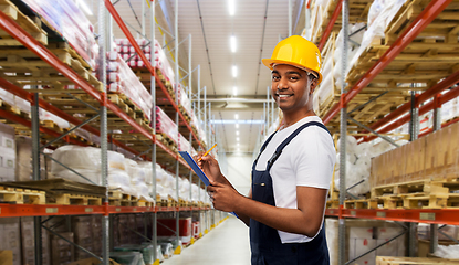 Image showing happy worker or loader with clipboard at warehouse