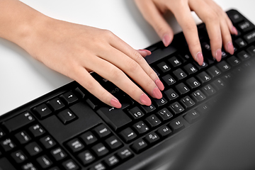 Image showing female hands typing on computer keyboard on table