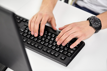 Image showing male hands typing on computer keyboard on table