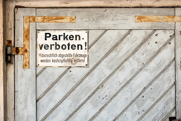 Image showing private no parking sign with german text Illegally parked vehicl